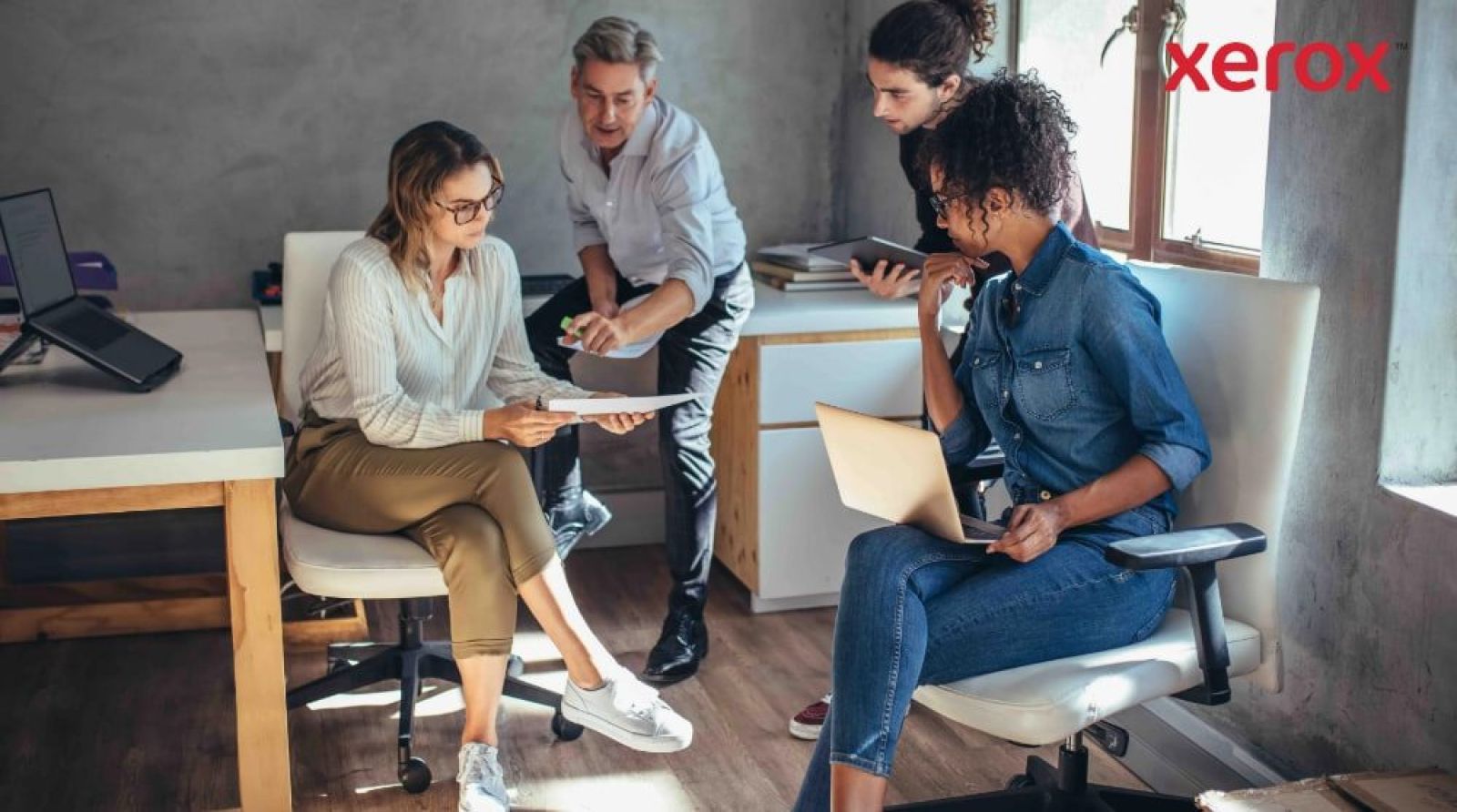 Four colleagues collaborating in a modern office. Four colleagues collaborating in a modern office.
