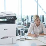 Xerox® VersaLink® C625 Colour Multifunction Printer in the workplace Two women working in an office next to a Xerox® VersaLink® C625 Colour Multifunction Printer
